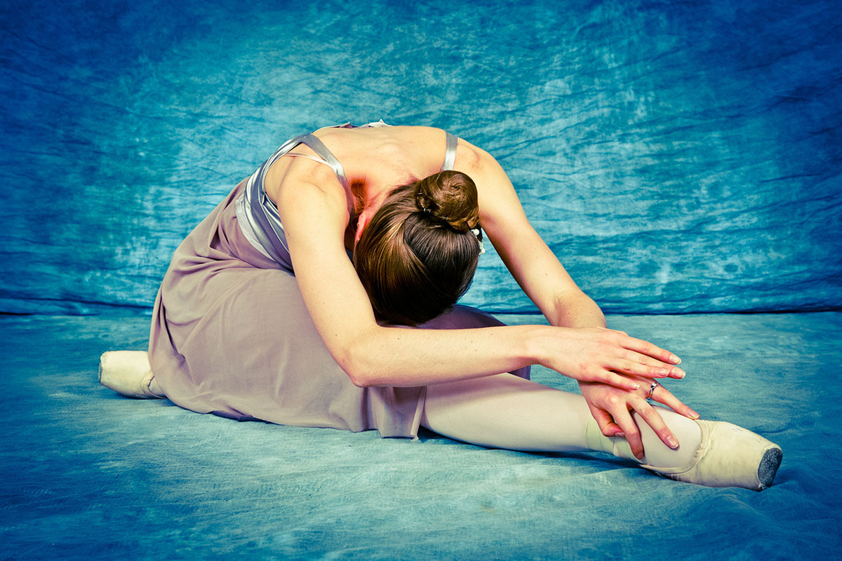 Ballerina stretching forward bend on the floor